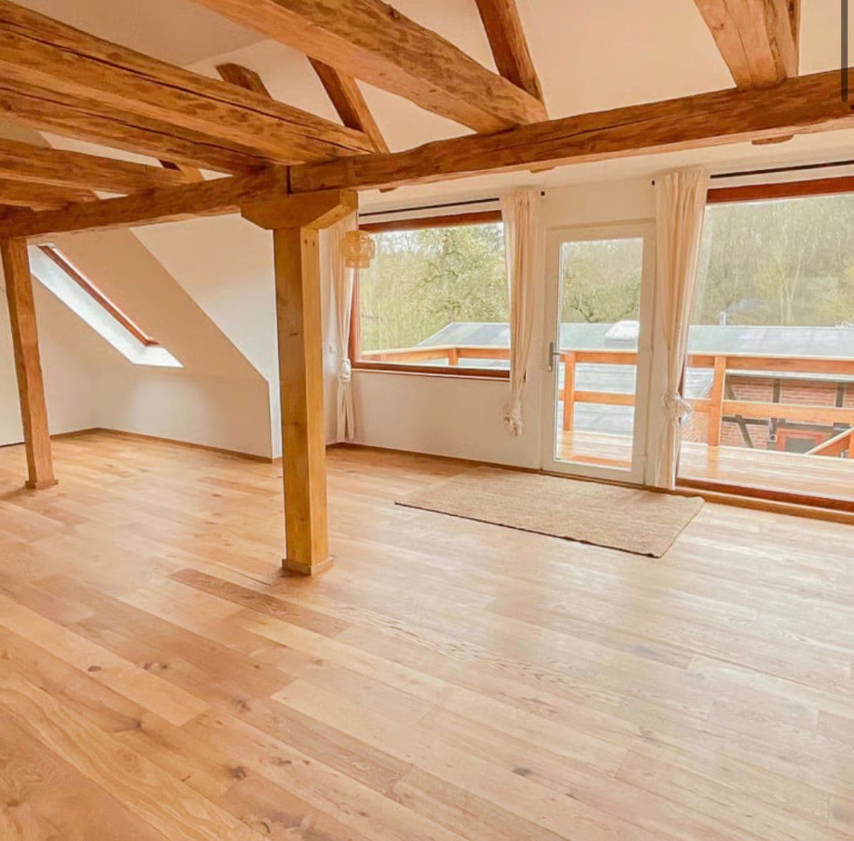 Heller Gruppenraum des Retreat Centers mit Holzbalken und großen Fenstern