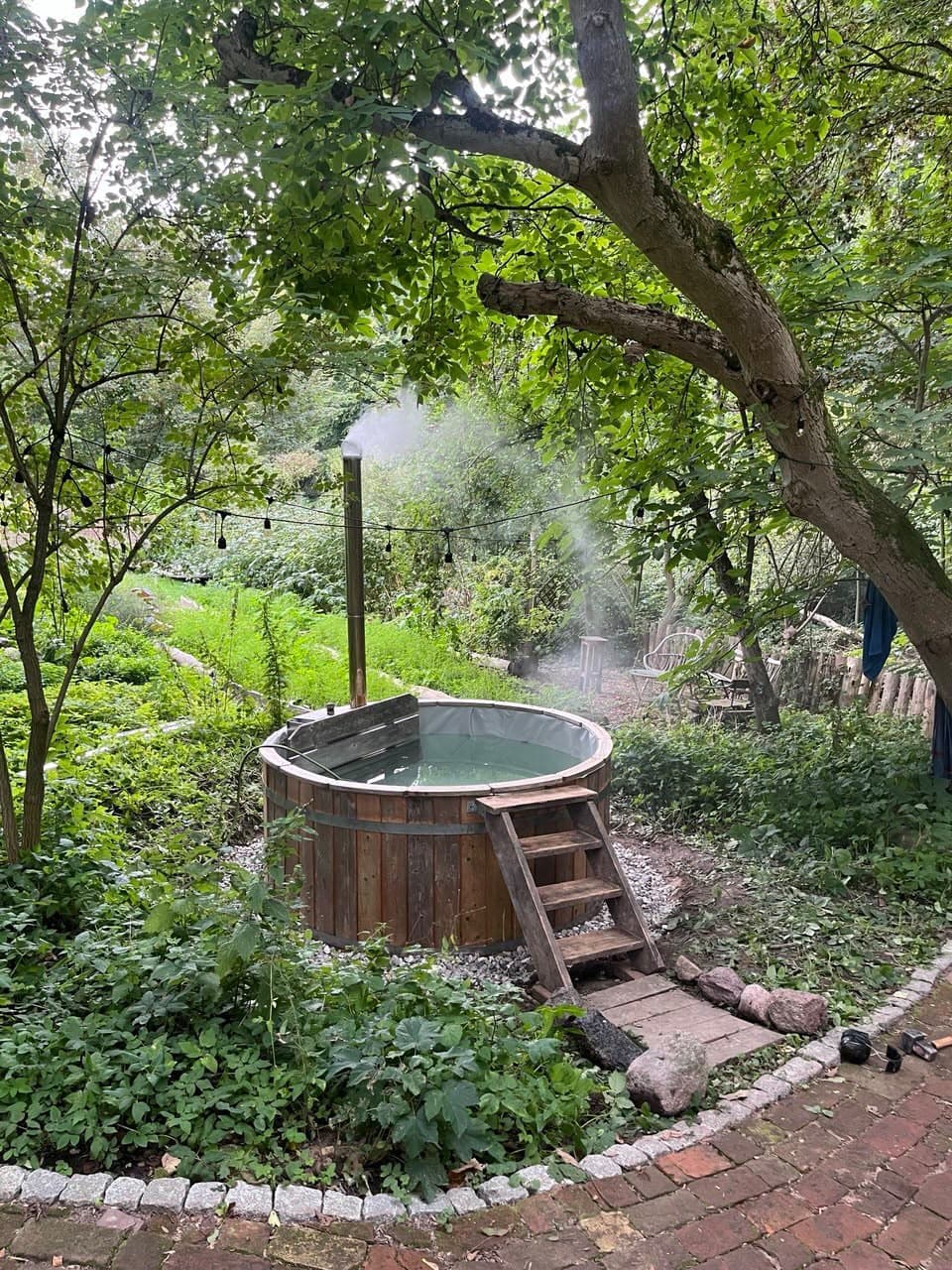 Warmer Hot Tub unter Bäumen im Garten des Retreat Centers